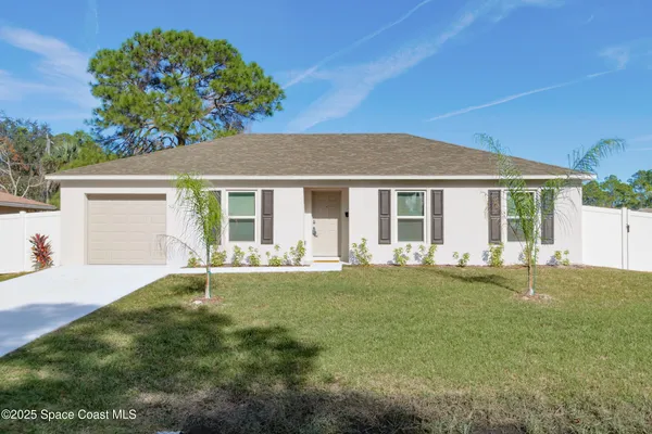 a front view of a house with a garden