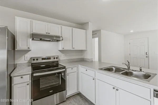 a kitchen with appliances a sink and cabinets