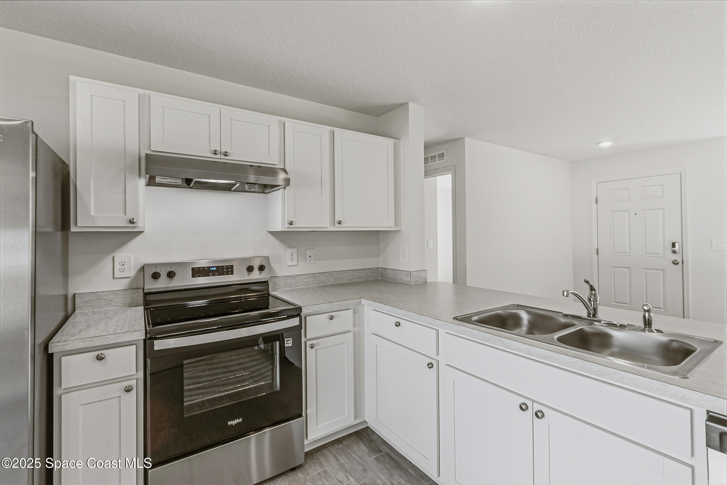 511 Trumpet Street Southwest Palm Bay, FL 32908 - Photo 31 of 43 a kitchen with appliances a sink and cabinets