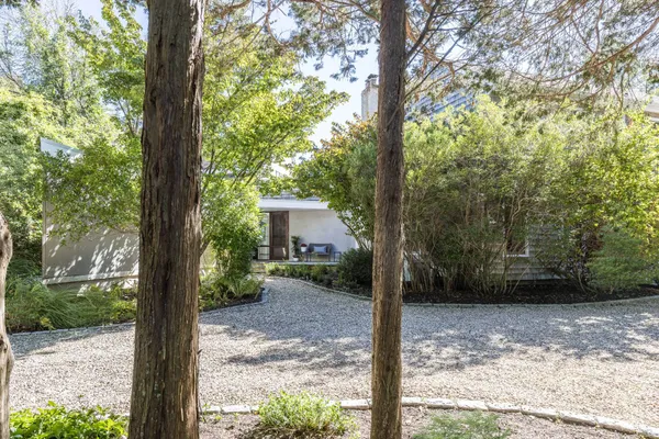a view of a house with backyard and trees
