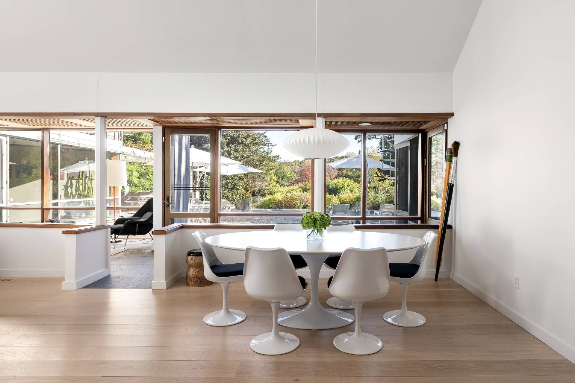 4108 Noyack Road Sag Harbor, NY 11963 - Photo 6 of 26 a dining room with wooden floor and large windows