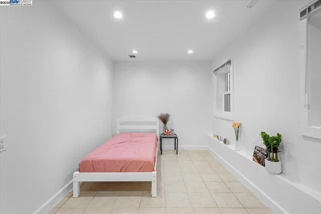 a bedroom with a bed and a potted plant