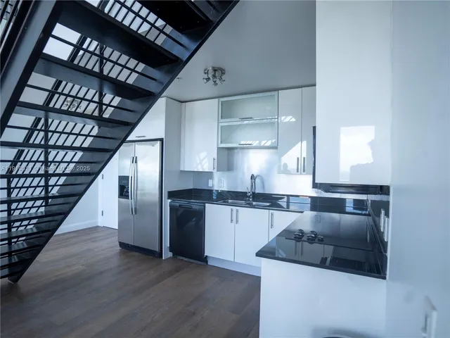 a kitchen with stainless steel appliances granite countertop a sink stove and cabinets