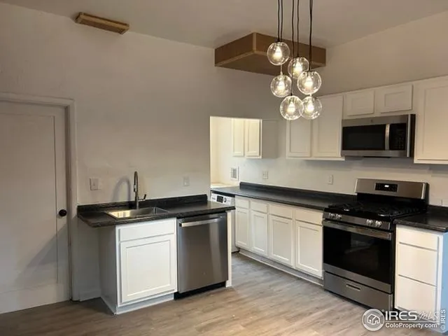 a kitchen with stainless steel appliances granite countertop a sink a stove and microwave