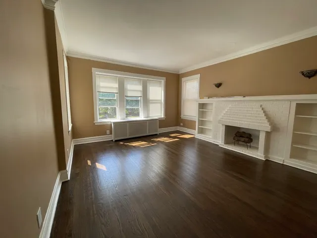an empty room with wooden floor and a fireplace