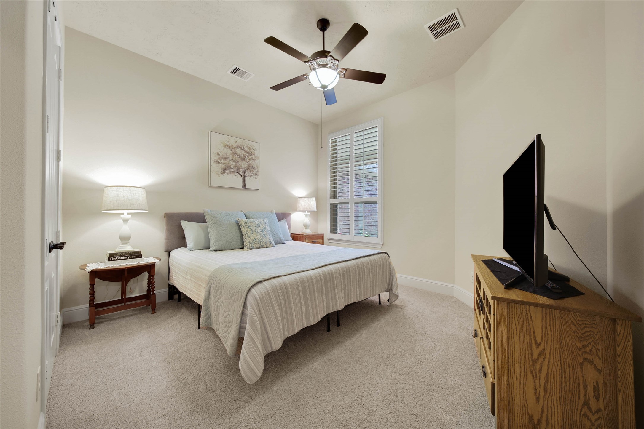 3234 Explorer Way Conroe, TX 77301 - Photo 30 of 44 a spacious bedroom with a bed and a flat screen tv