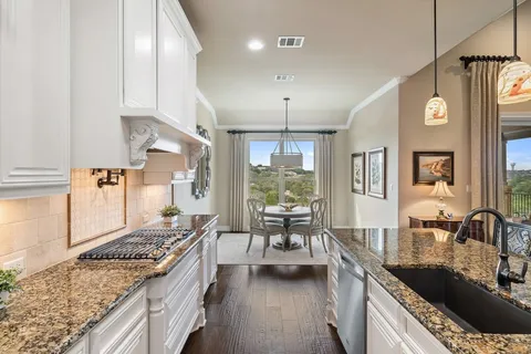 a kitchen with stainless steel appliances granite countertop a sink stove and cabinets