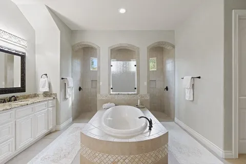 a spacious bathroom with a tub sink mirror and vanity