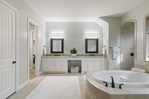a large white bathroom with a large tub and sink
