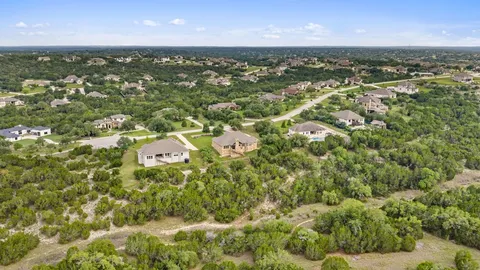 an aerial view of residential houses with outdoor space and trees