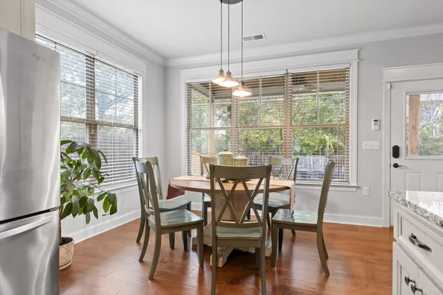 a dining room with furniture potted plants and wooden floor
