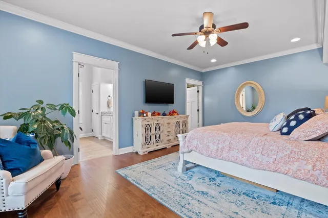 a bedroom with a bed and a flat tv screen on dresser