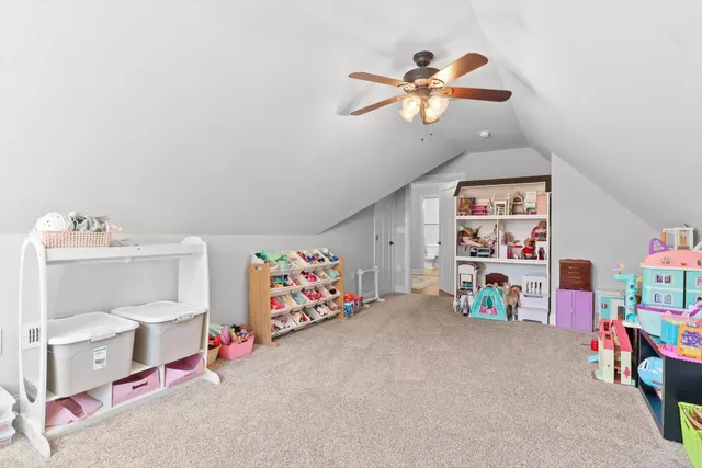 a view of play room with toys and ceiling fan
