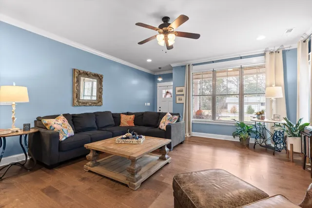 a living room with furniture ceiling fan and a window