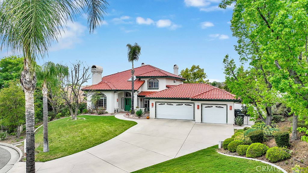 a front view of a house with a garden and trees