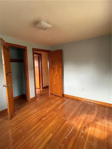 a view of an empty room with closet and a window