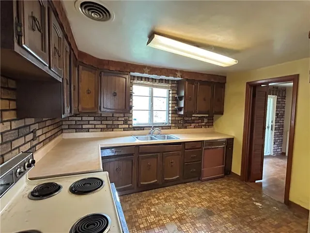 a kitchen with a sink a stove and cabinets