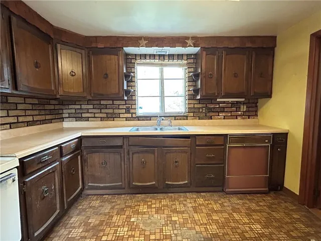 a kitchen with a sink window and cabinets