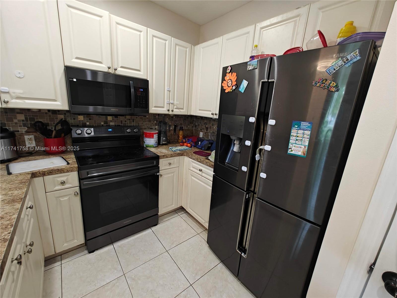 2583 Riverside Drive, Unit 2583 Coral Springs, FL 33065 - Photo 11 of 33 a kitchen with stainless steel appliances a refrigerator a stove a microwave and cabinets