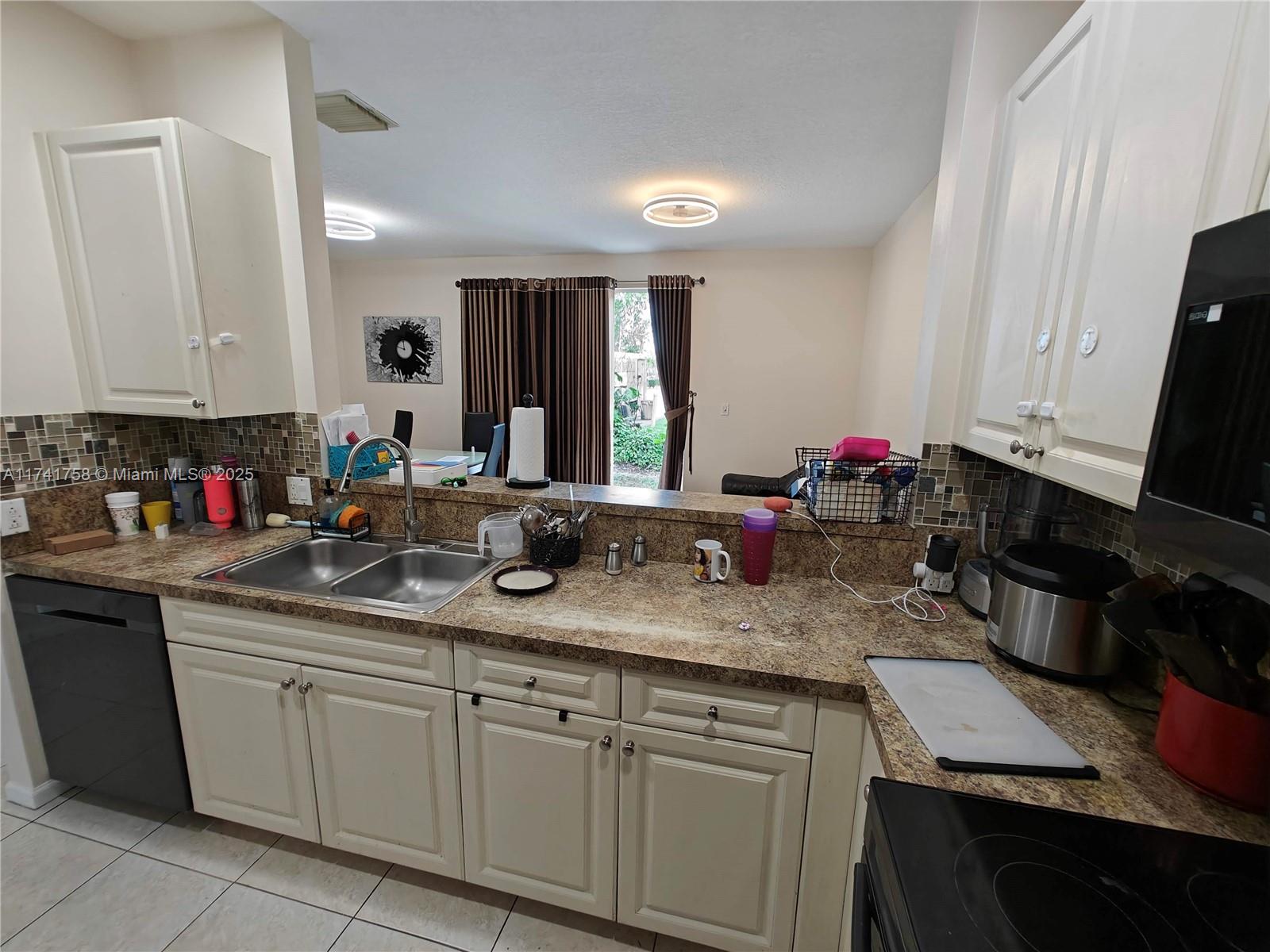 2583 Riverside Drive, Unit 2583 Coral Springs, FL 33065 - Photo 12 of 33 a kitchen with sink and cabinets