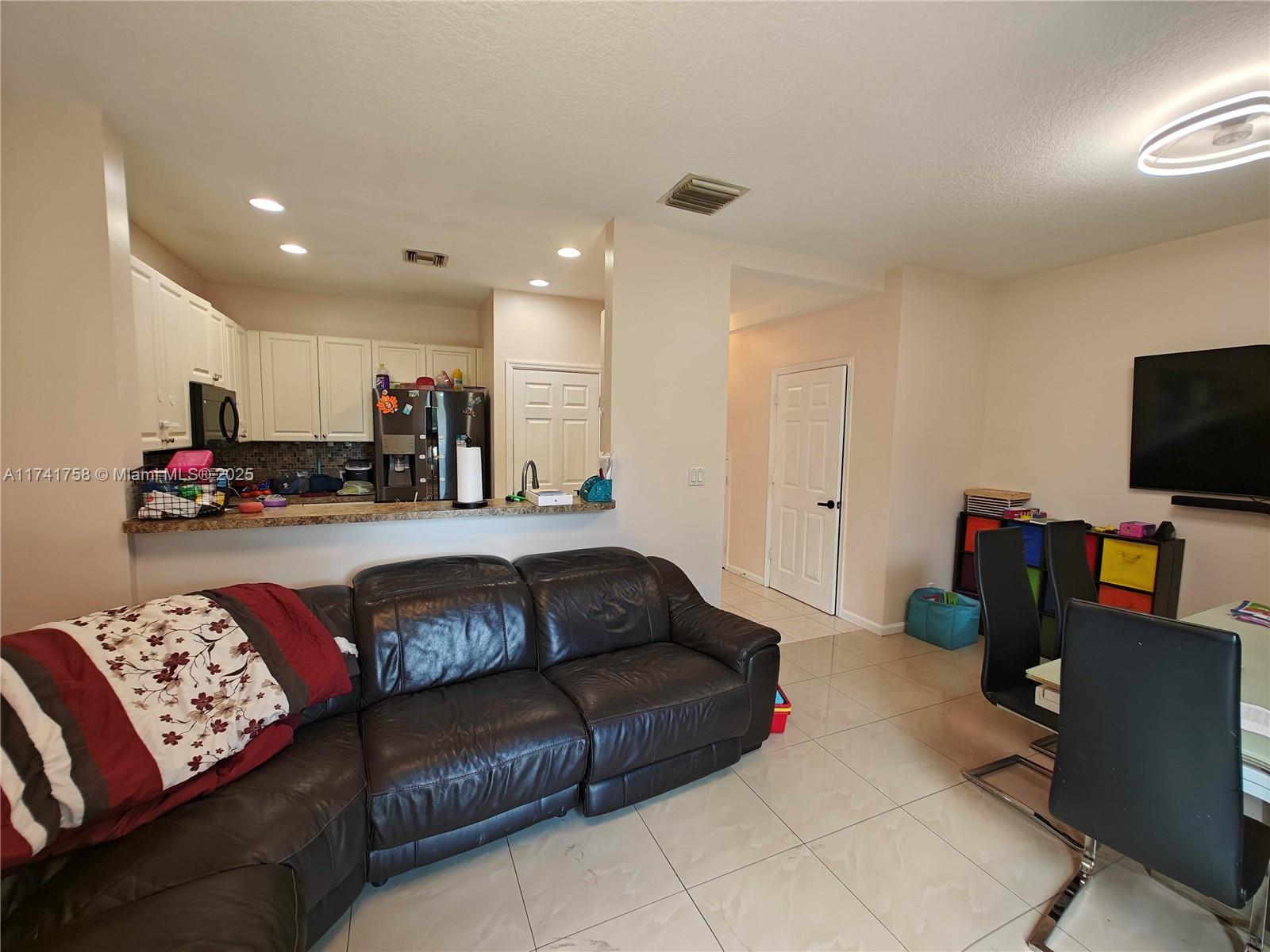 2583 Riverside Drive, Unit 2583 Coral Springs, FL 33065 - Photo 14 of 33 a living room with furniture and a flat screen tv