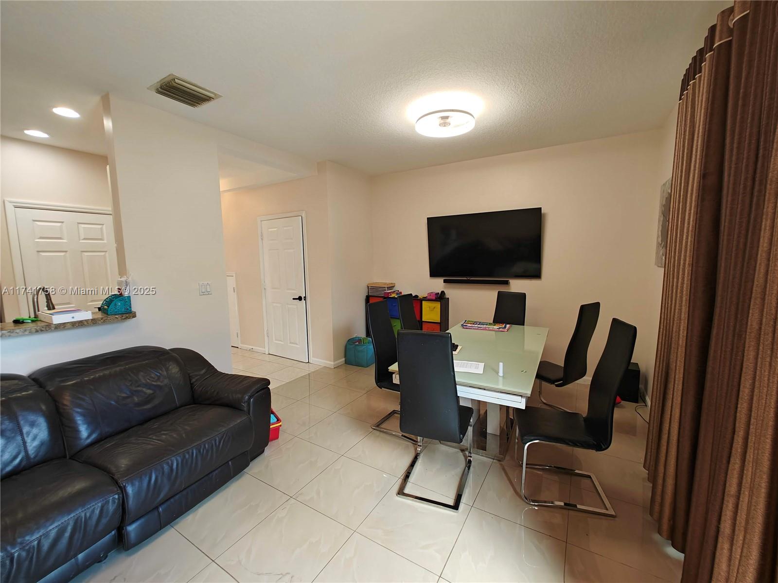 2583 Riverside Drive, Unit 2583 Coral Springs, FL 33065 - Photo 17 of 33 a living room with furniture and a flat screen tv