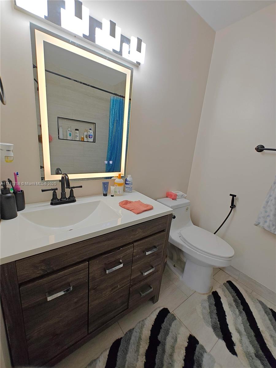 2583 Riverside Drive, Unit 2583 Coral Springs, FL 33065 - Photo 25 of 33 a bathroom with a granite countertop toilet sink and mirror