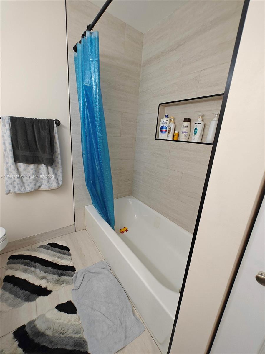 2583 Riverside Drive, Unit 2583 Coral Springs, FL 33065 - Photo 26 of 33 a bathroom with a bathtub and a shower
