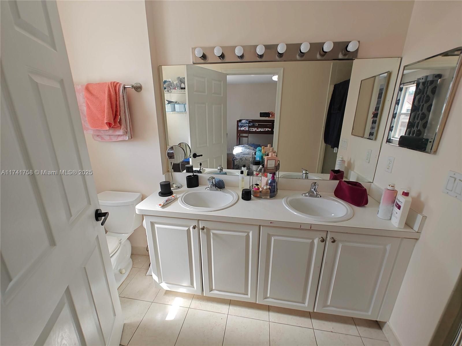 2583 Riverside Drive, Unit 2583 Coral Springs, FL 33065 - Photo 31 of 33 a bathroom with a sink a toilet and mirror