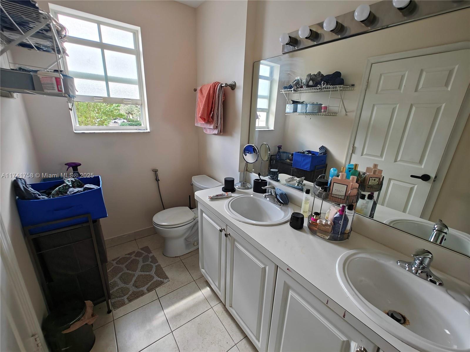 2583 Riverside Drive, Unit 2583 Coral Springs, FL 33065 - Photo 33 of 33 a bathroom with a sink a toilet and a mirror