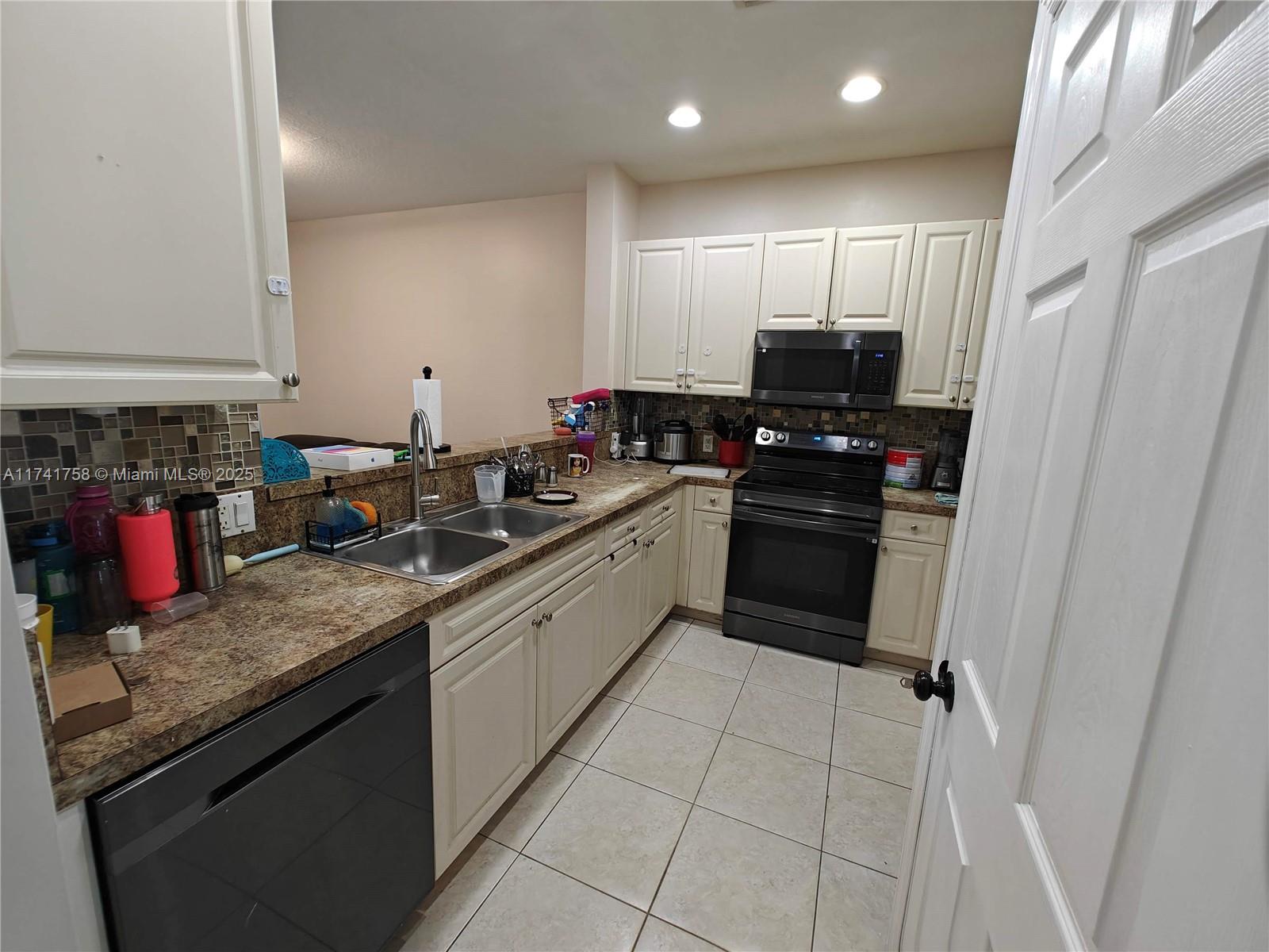 2583 Riverside Drive, Unit 2583 Coral Springs, FL 33065 - Photo 8 of 33 a kitchen with stainless steel appliances granite countertop a sink stove and cabinets