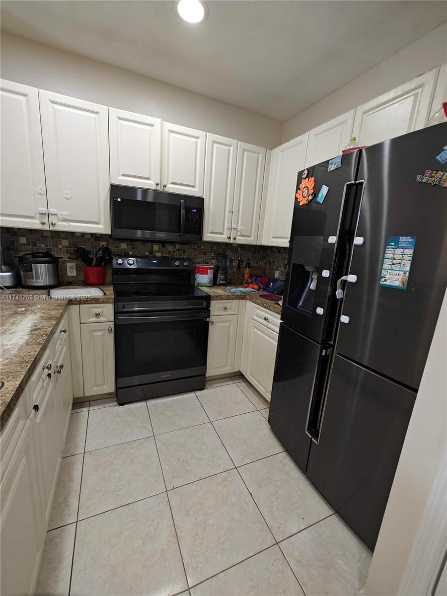2583 Riverside Drive, Unit 2583 Coral Springs, FL 33065 - Photo 10 of 33 a kitchen with a sink a stove and refrigerator