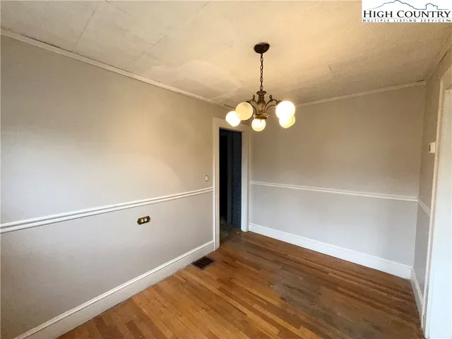 a view of a chandelier fan and wooden floor