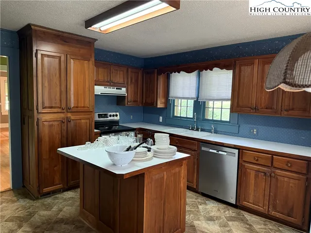 a kitchen with granite countertop a sink stove and refrigerator