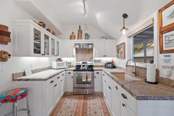 a kitchen with a sink stove and cabinets