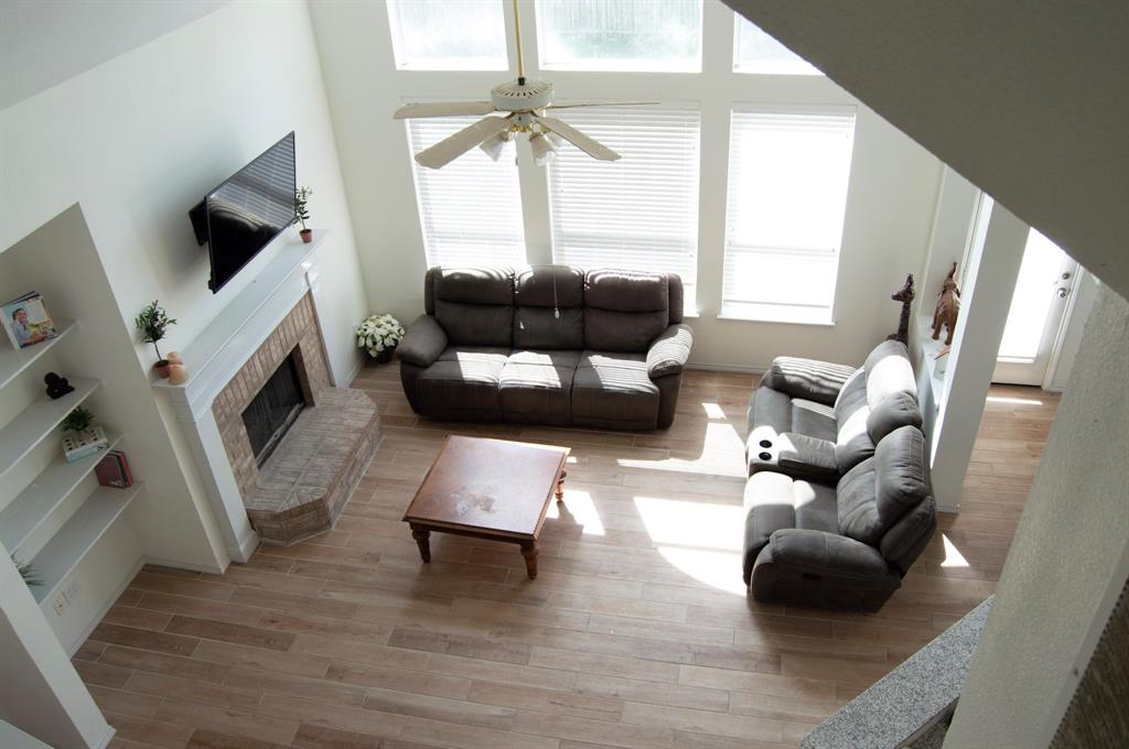 2700 Hereford Road Denton, TX 76210 - Photo 11 of 38 Living area featuring a high ceiling, light wood finished floors, a brick fireplace, and ceiling fan