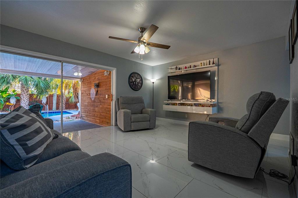 5124 Springwood Drive Tampa, FL 33624 - Photo 18 of 53 a living room with furniture and a flat screen tv