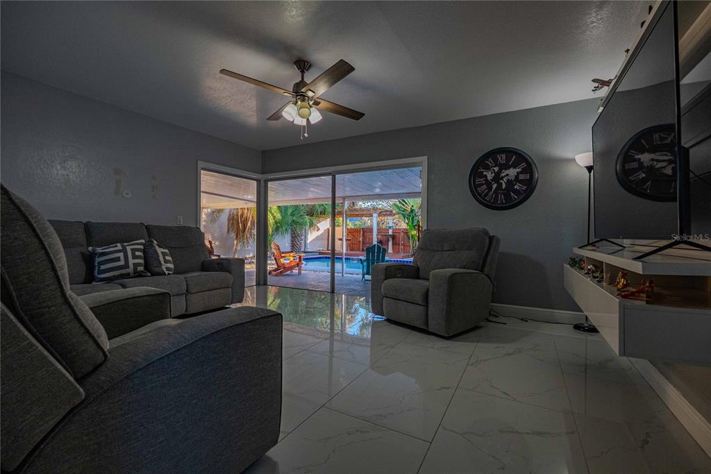 5124 Springwood Drive Tampa, FL 33624 - Photo 3 of 53 a living room with furniture a clock and a window