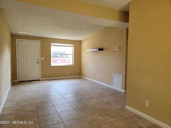 an empty room with windows and closet