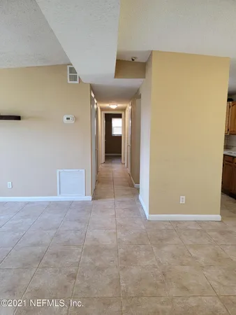 a view of a hallway with wooden cabinets