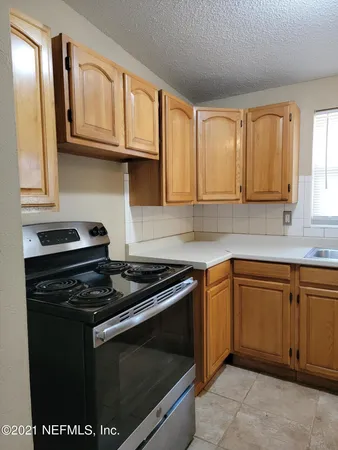 a kitchen with granite countertop wooden cabinets and a stove top oven
