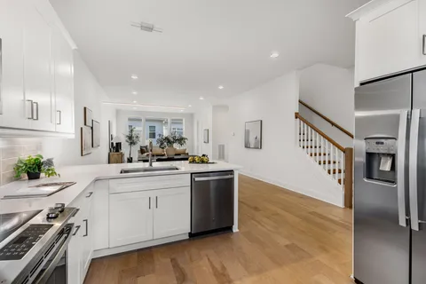 a kitchen with stainless steel appliances granite countertop a sink stove and refrigerator