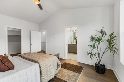 a bedroom with a large bed and a potted plant