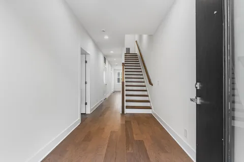a view of a hallway with wooden floor