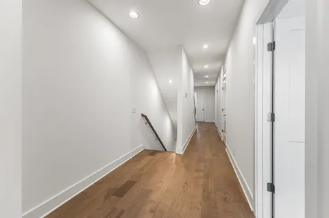a view of a hallway with wooden floor