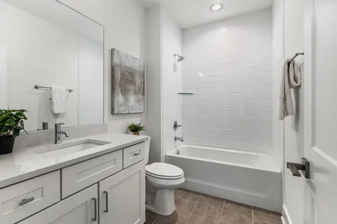 a bathroom with a granite countertop sink a toilet and shower