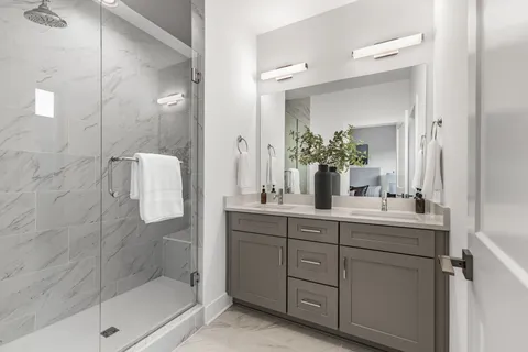 a bathroom with a double vanity sink mirror and shower