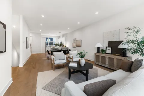 a living room with furniture and a dining table with kitchen view