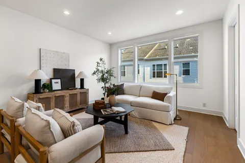 a living room with furniture a flat screen tv and a fireplace