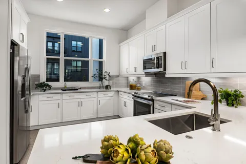 a kitchen with granite countertop a sink stainless steel appliances and cabinets